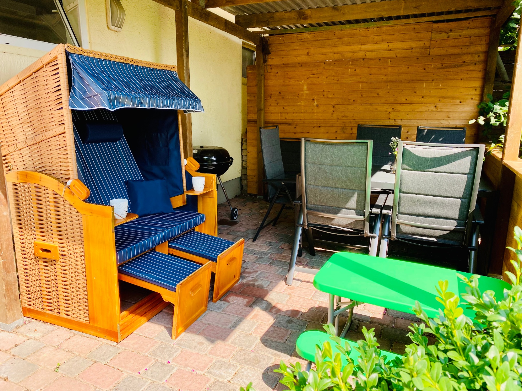 Überdachte Terrasse mit Strandkorb und Sitzgruppe